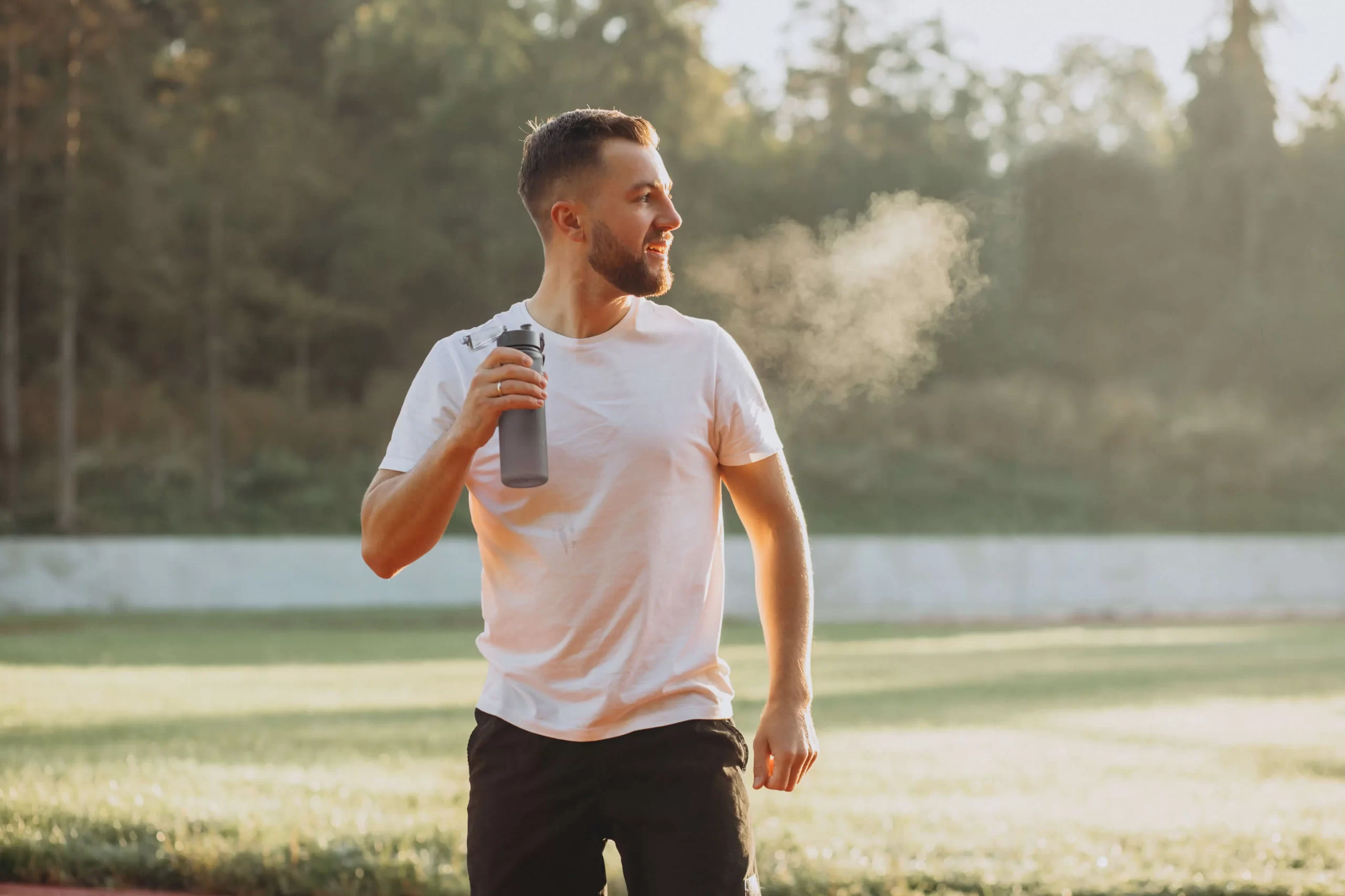 Athletic man wearing a white t-shirt and black shorts standing outdoors