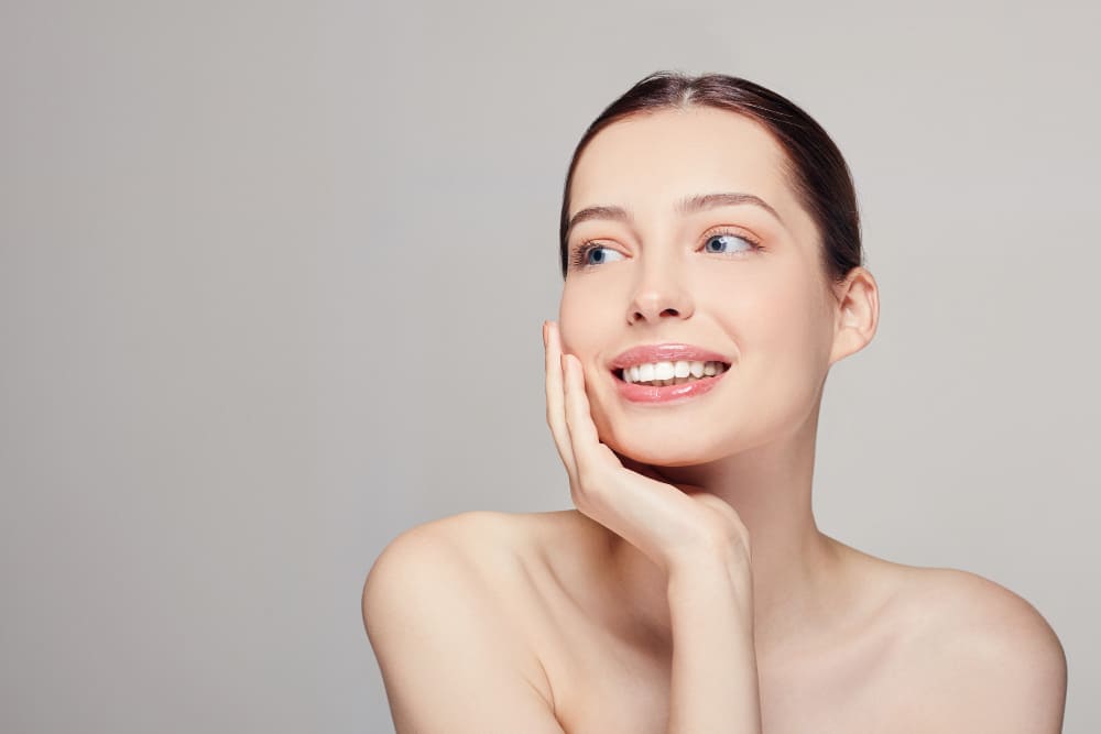 Beautiful young woman with clean fresh skin, blue eyes and dark hear smiling