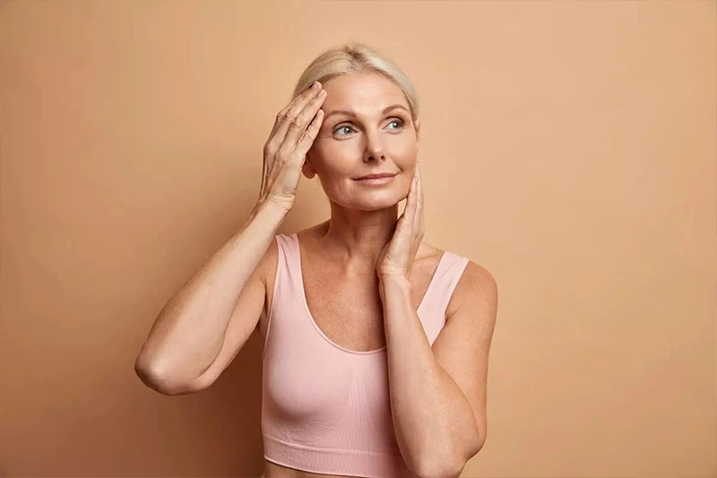 Portrait mature elderly european woman touches face gently